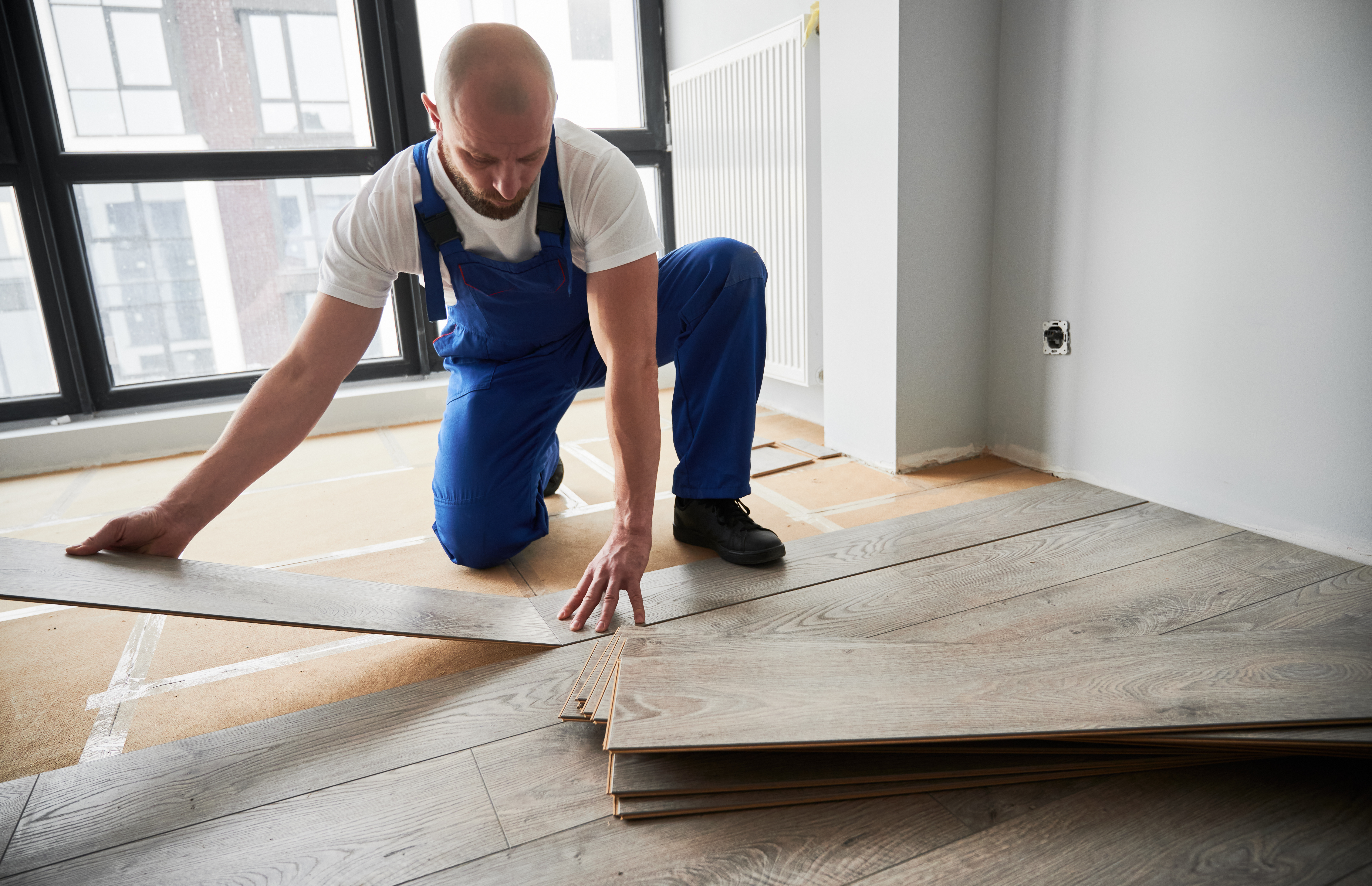 a white room with wood flooring and a large window