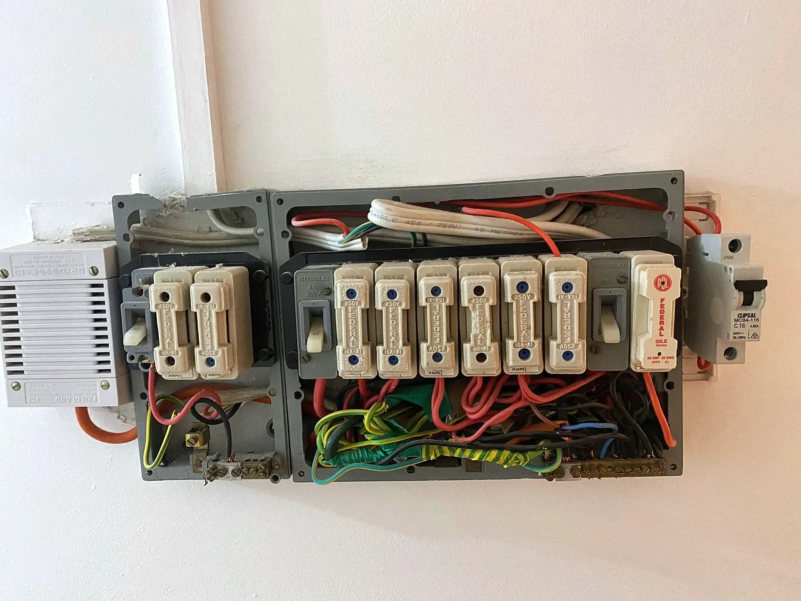 An old switchboard with ceramic fuses and loose wiring