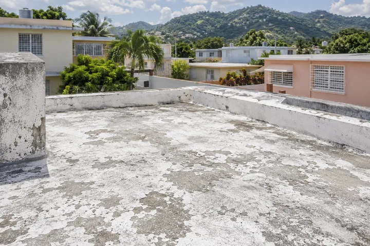Imagen conceptual: Recubrimiento desgastado en un techo plano residencial de Puerto Rico.