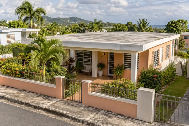Imagen conceptual: Casa de hormigón color melocotón con marquesina y techo plano en Puerto Rico.