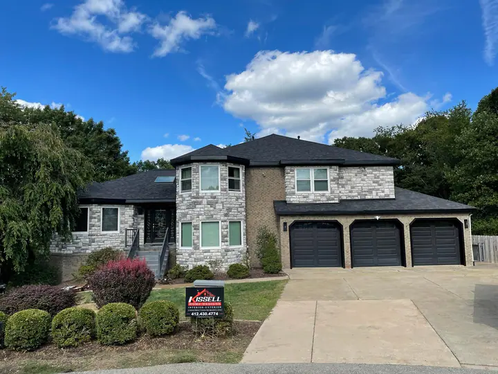 Finished front elevation with a black onyx roof and stone veneer