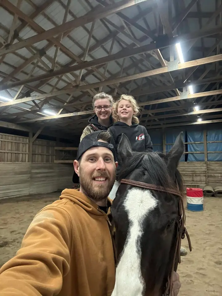 Ben Kissell with his daughter on a horse and Bryanna at the riding arena