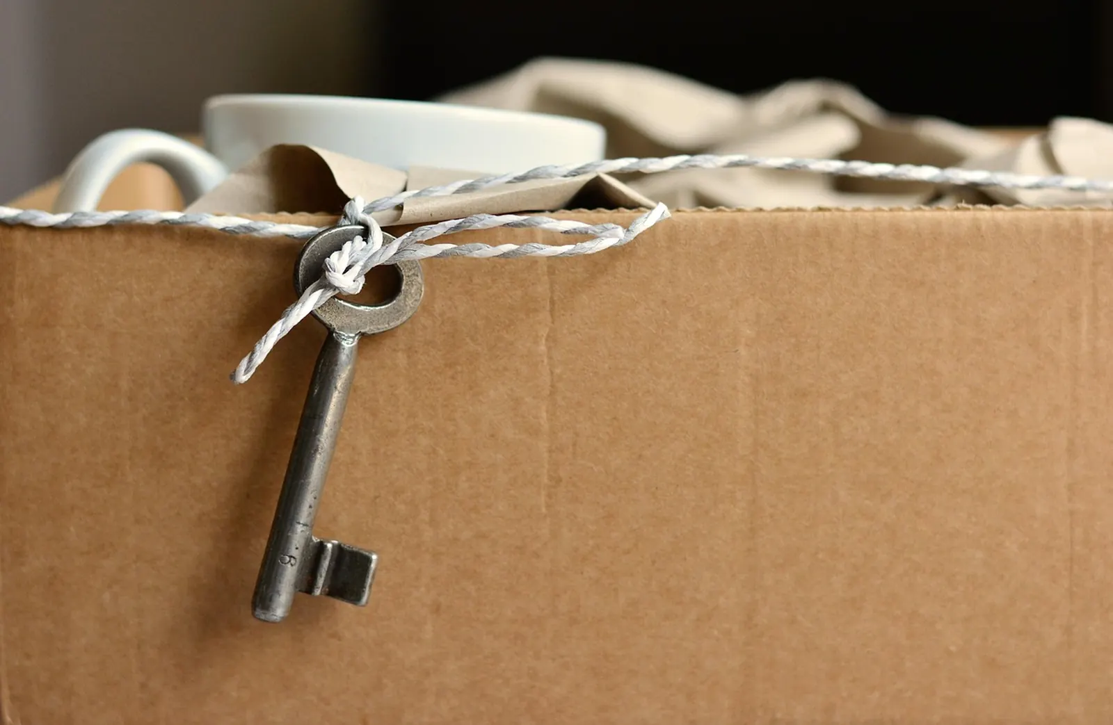 Caja de mudanza cerrada con la llave de la casa nueva encima