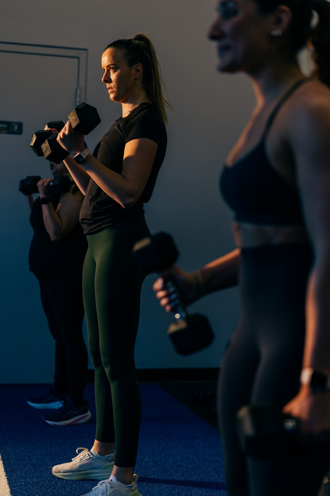 Members working through dumbbell curls in an F45 class