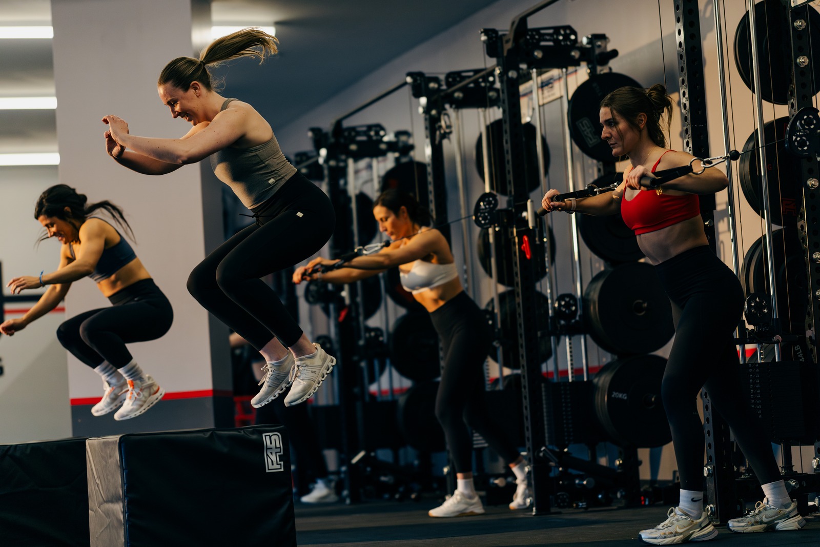 F45 members mid-class — box jumps and cable work on the training floor
