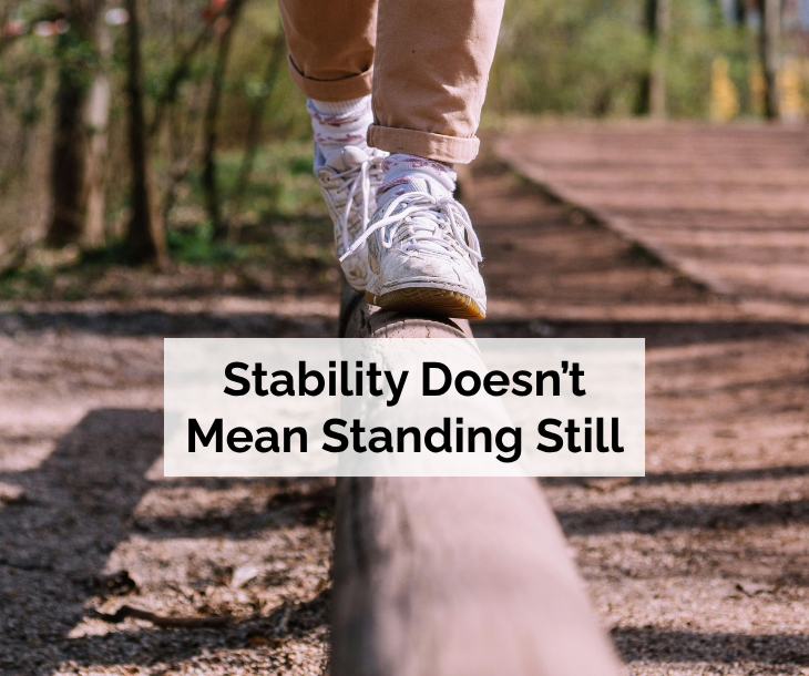 Person walking forward while balancing on a narrow beam, representing business stability and financial resilience