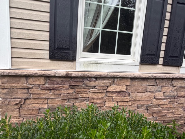 Stone veneer and window exterior before professional cleaning by Thin Red Line Pressure Washing in Clifton Park, NY.