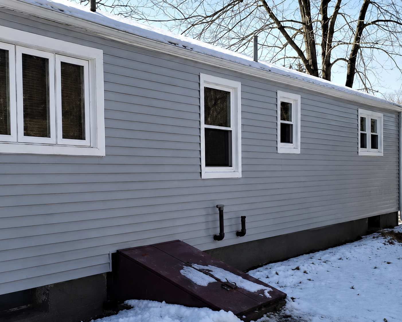 Clean residential vinyl siding after soft house washing by Thin Red Line Pressure Washing in Clifton Park, NY.
