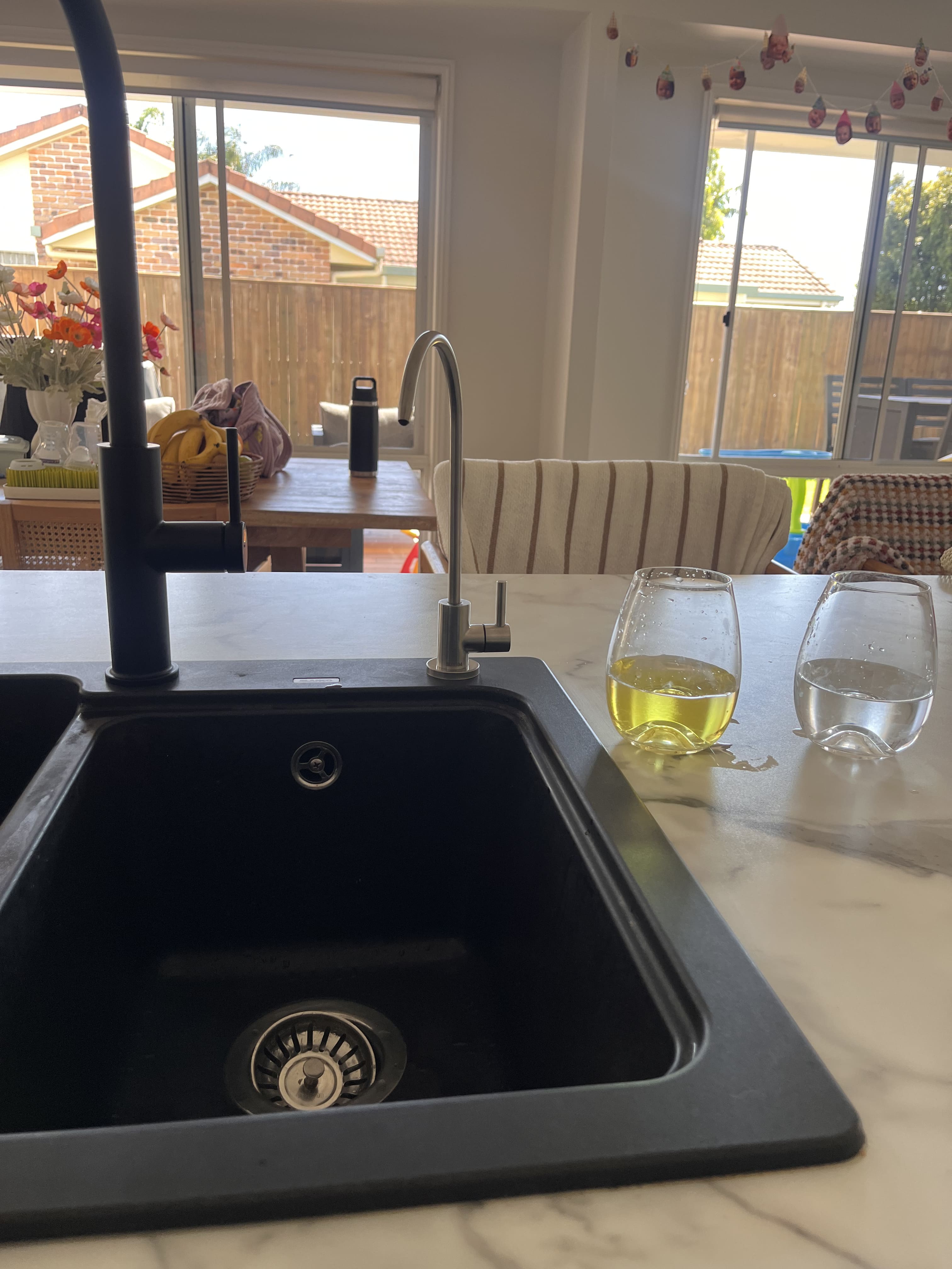 Whole house water filtration housings mounted beside a hot water unit in Currimundi