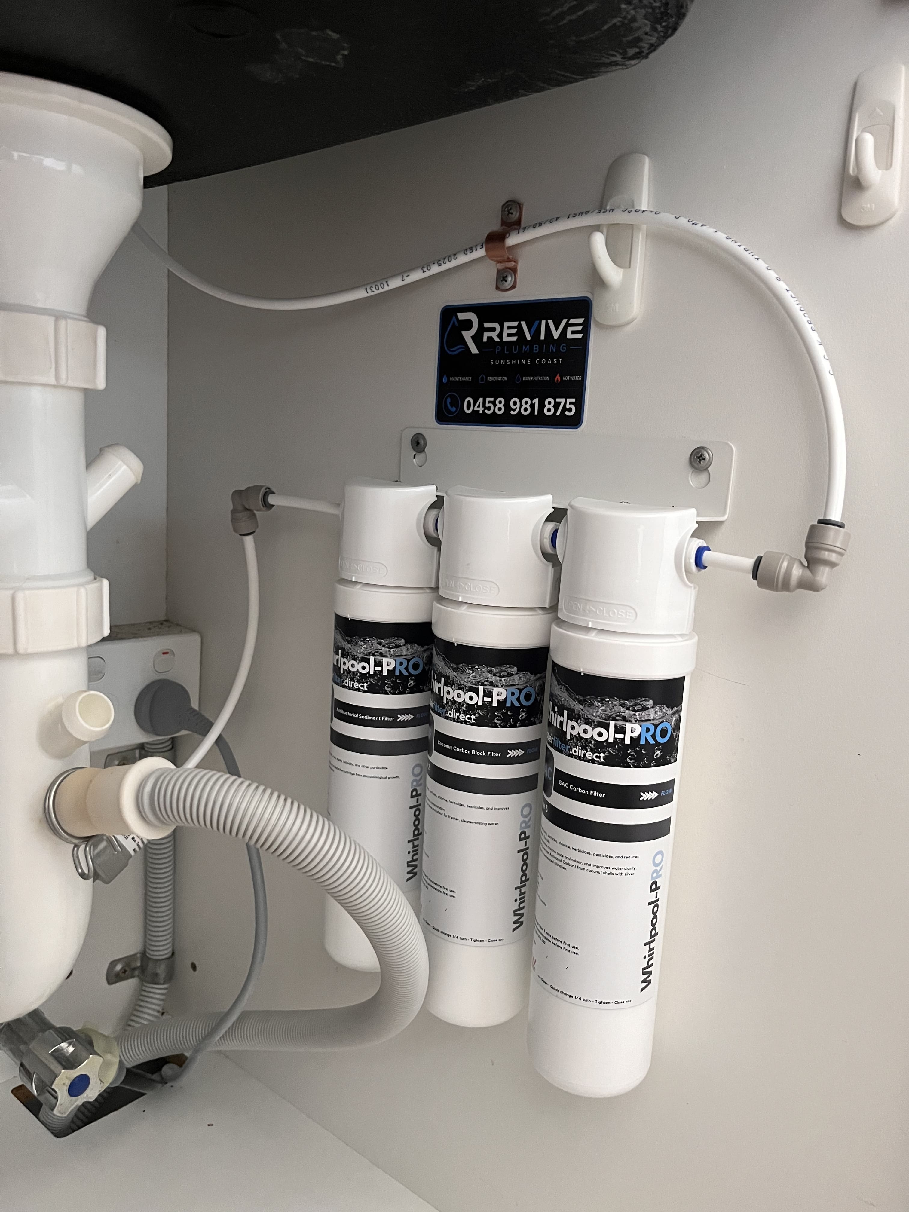 Whole house water filter housings installed on an external wall on the Sunshine Coast