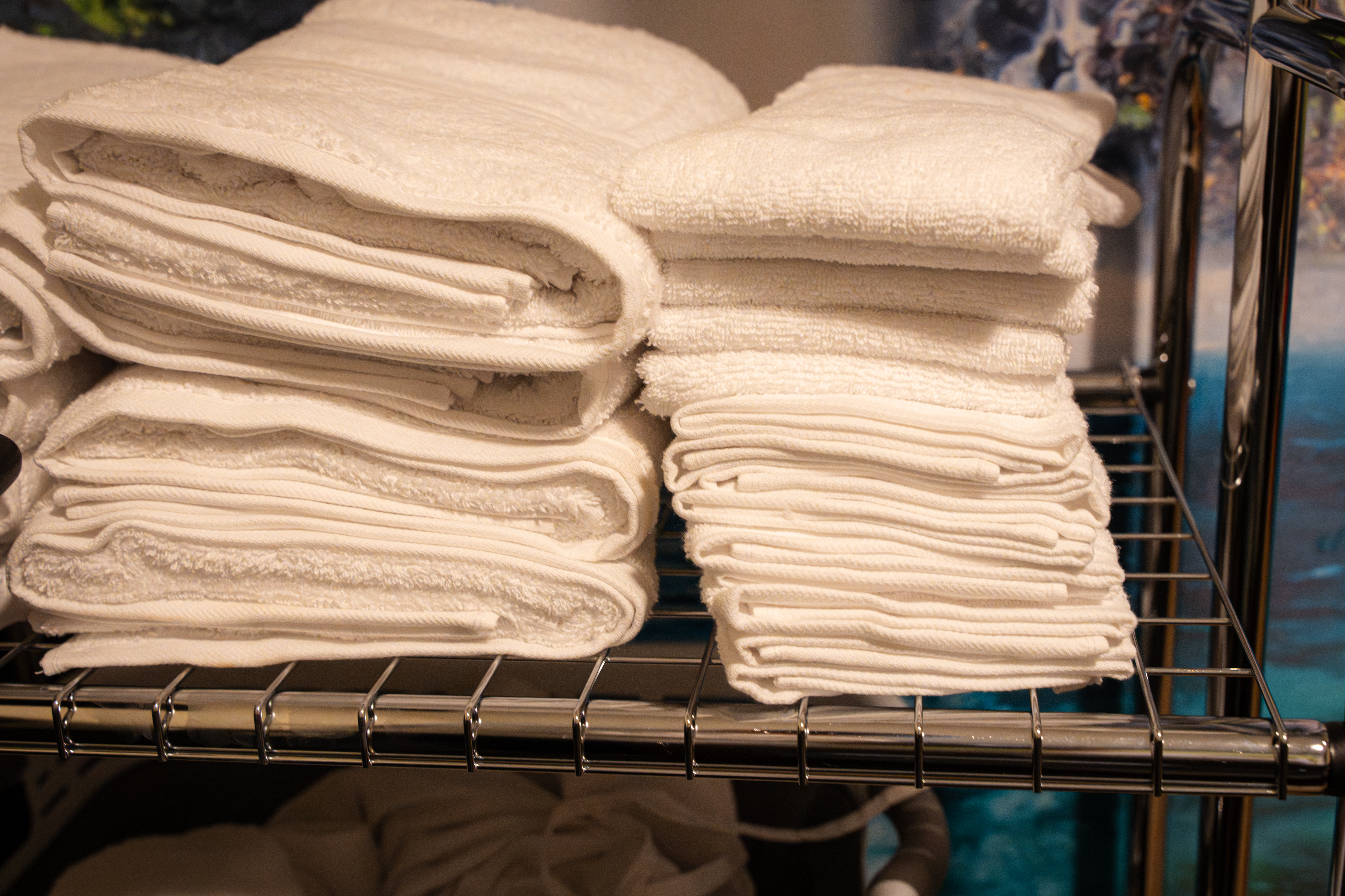 Crisp white folded towels on the prep shelf at CIMA Spa — fresh linens for every guest