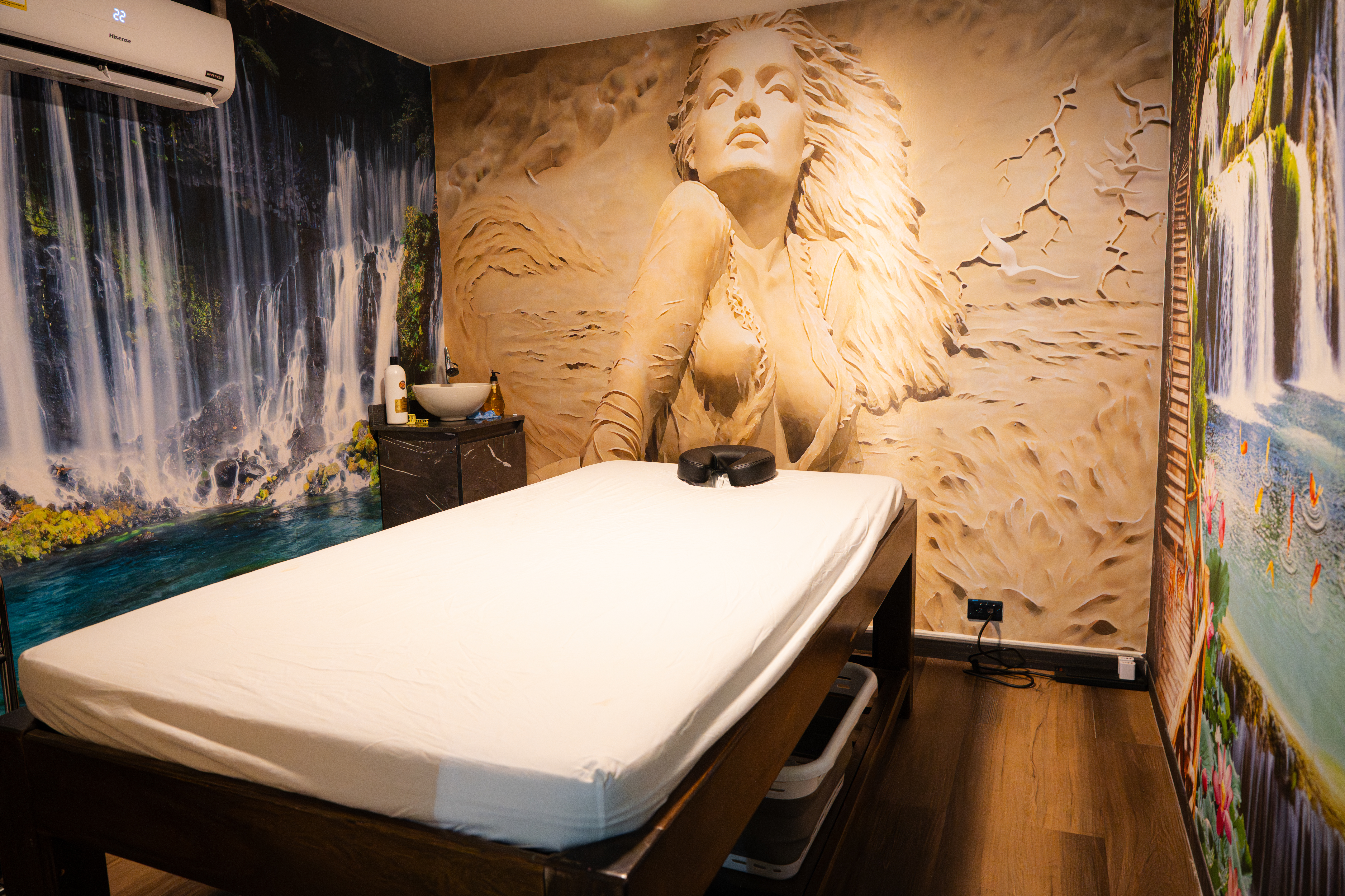 CIMA Spa signature treatment room featuring a hand-sculpted relief mural and waterfall imagery, Medellín