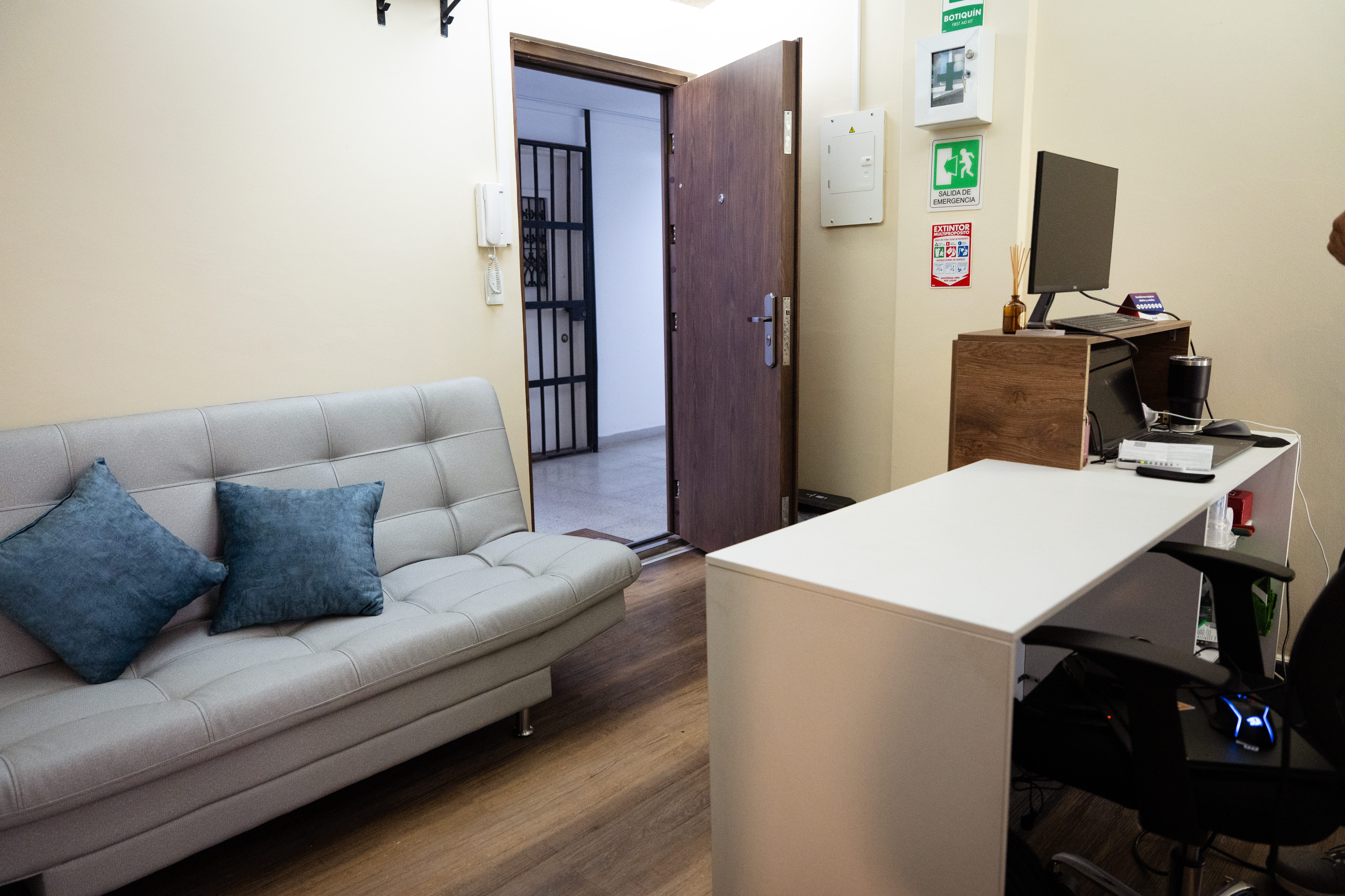 CIMA Spa reception lounge with grey sofa, blue accent pillows and front desk in El Poblado