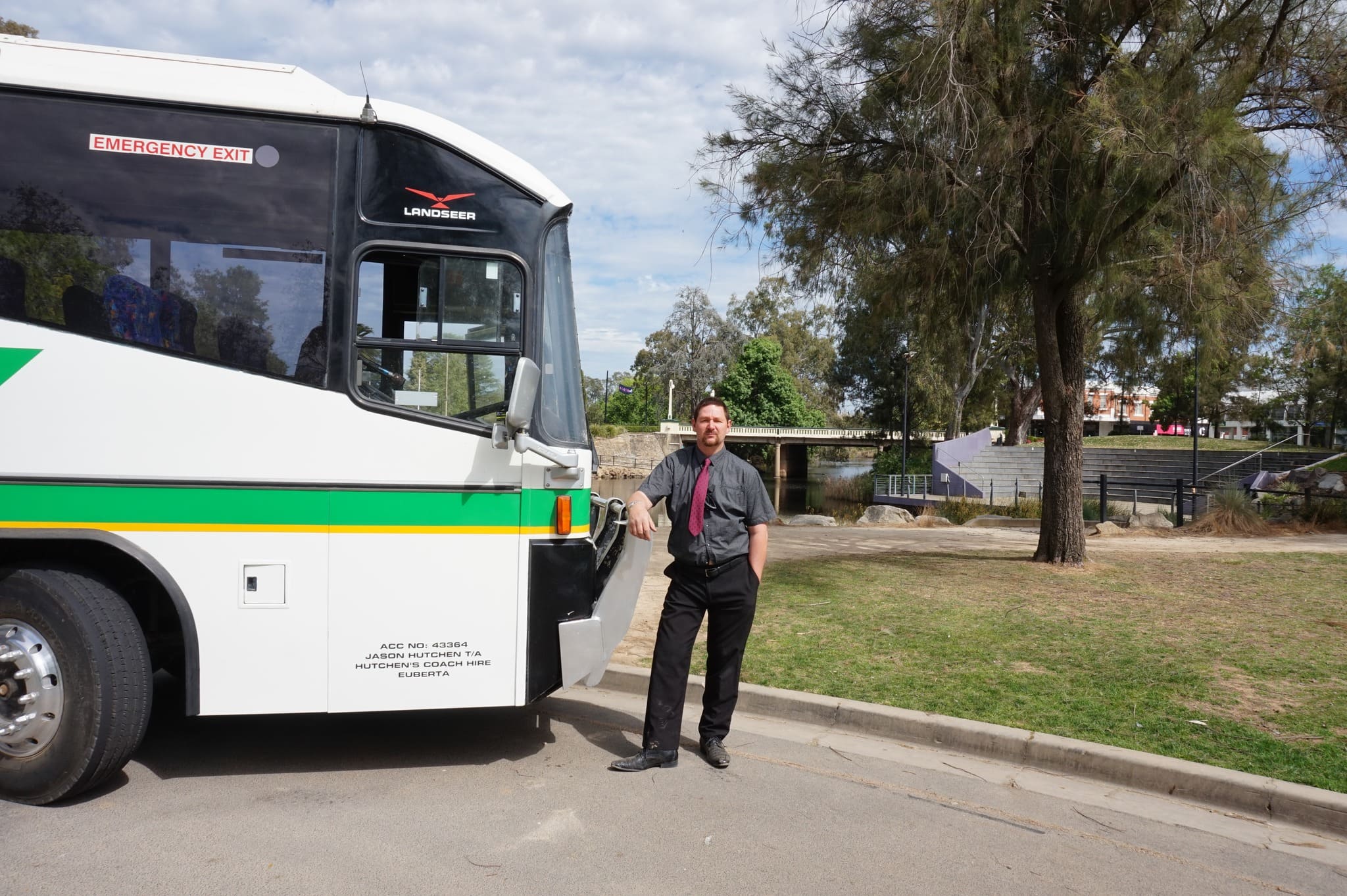 Jason Hutchen, Founder of Hutchen's Coach Hire, standing beside a premium coach