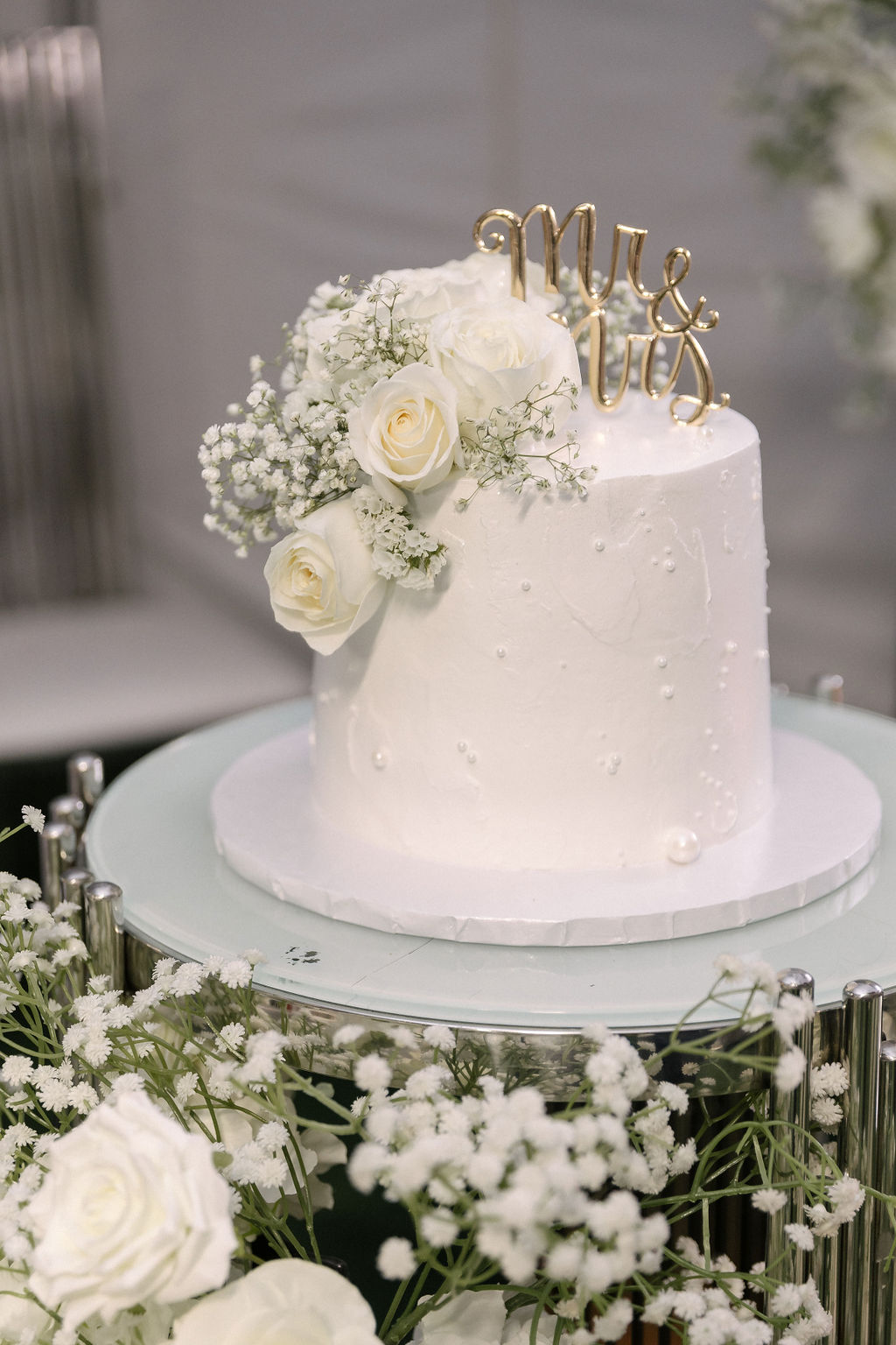 White pearl and rose baby's breath wedding cake with a gold Mr and Mrs topper by MJ Event Designs
