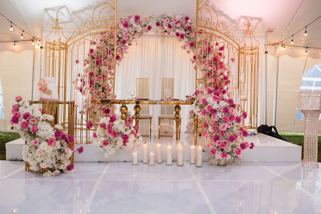 Wedding ceremony with a circular floral arch of white, pink and magenta roses by MJ Event Designs
