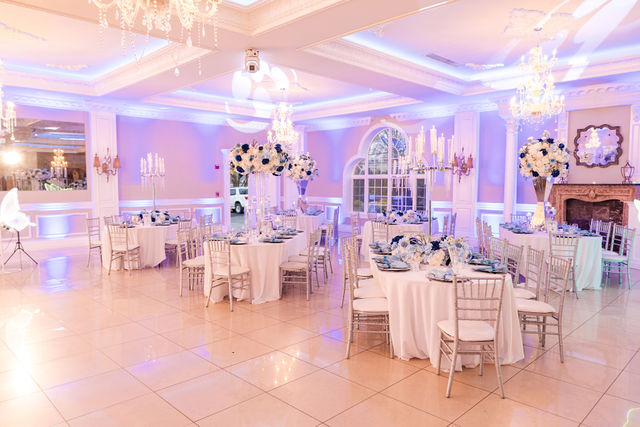 White and blue round floral sphere on a glass pedestal candelabra by MJ Event Designs
