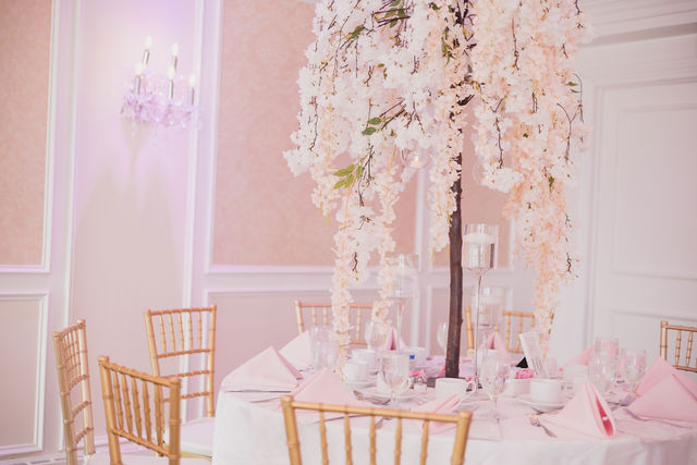 Pink and white cascading wisteria centerpiece with wood chairs by MJ Event Designs