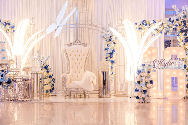 Sweet 16 white and silver tufted throne chair with an illuminated 16 and feathers by MJ Event Designs