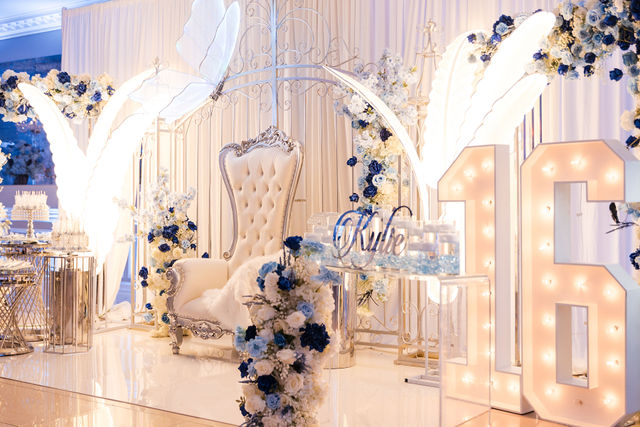 Sweet 16 with a royal blue floral arch, throne chair and illuminated 16 by MJ Event Designs