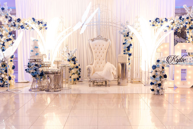 Sweet 16 with white and blue gold floral arches and a throne chair by MJ Event Designs