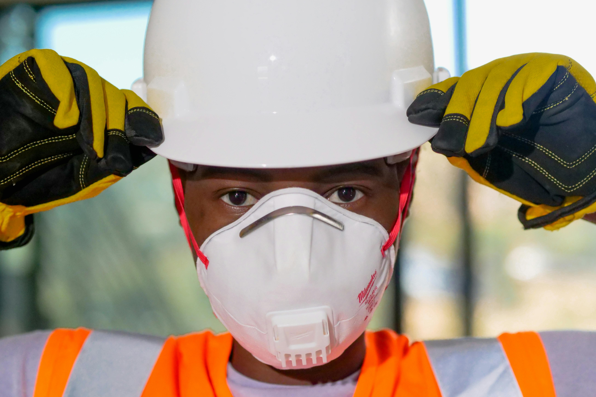 A boy wearing hard hat and a mask for safety precaution