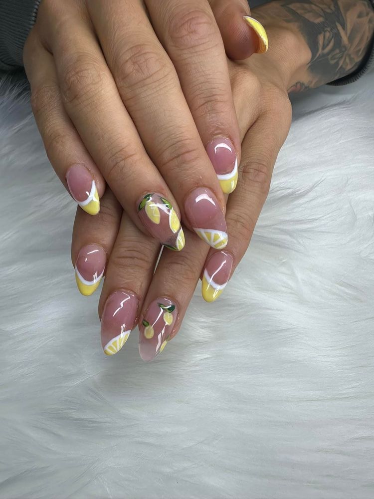 Almond nails with hand-painted lemons and yellow French tips