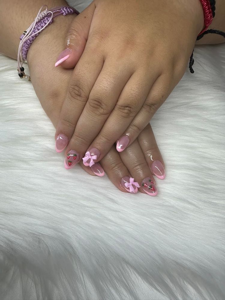 Short almond nails with pink French tips, painted strawberries and 3D bows