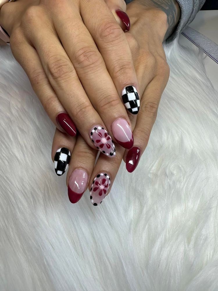 Burgundy almond nails with checkerboard and dotted flower accents