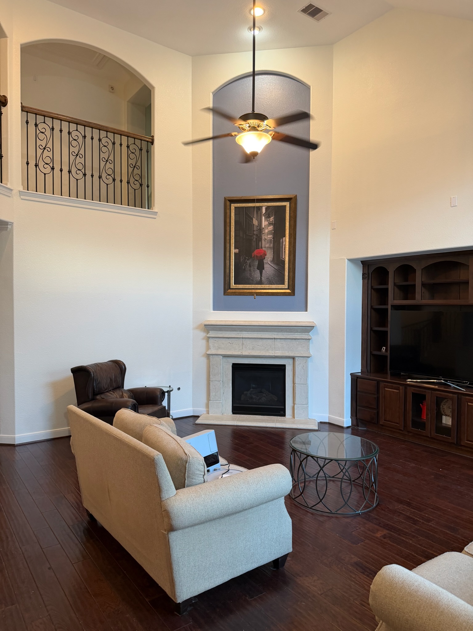 Luxury living room in Katy, Texas, featuring vaulted ceilings and a modern navy blue accent wall.