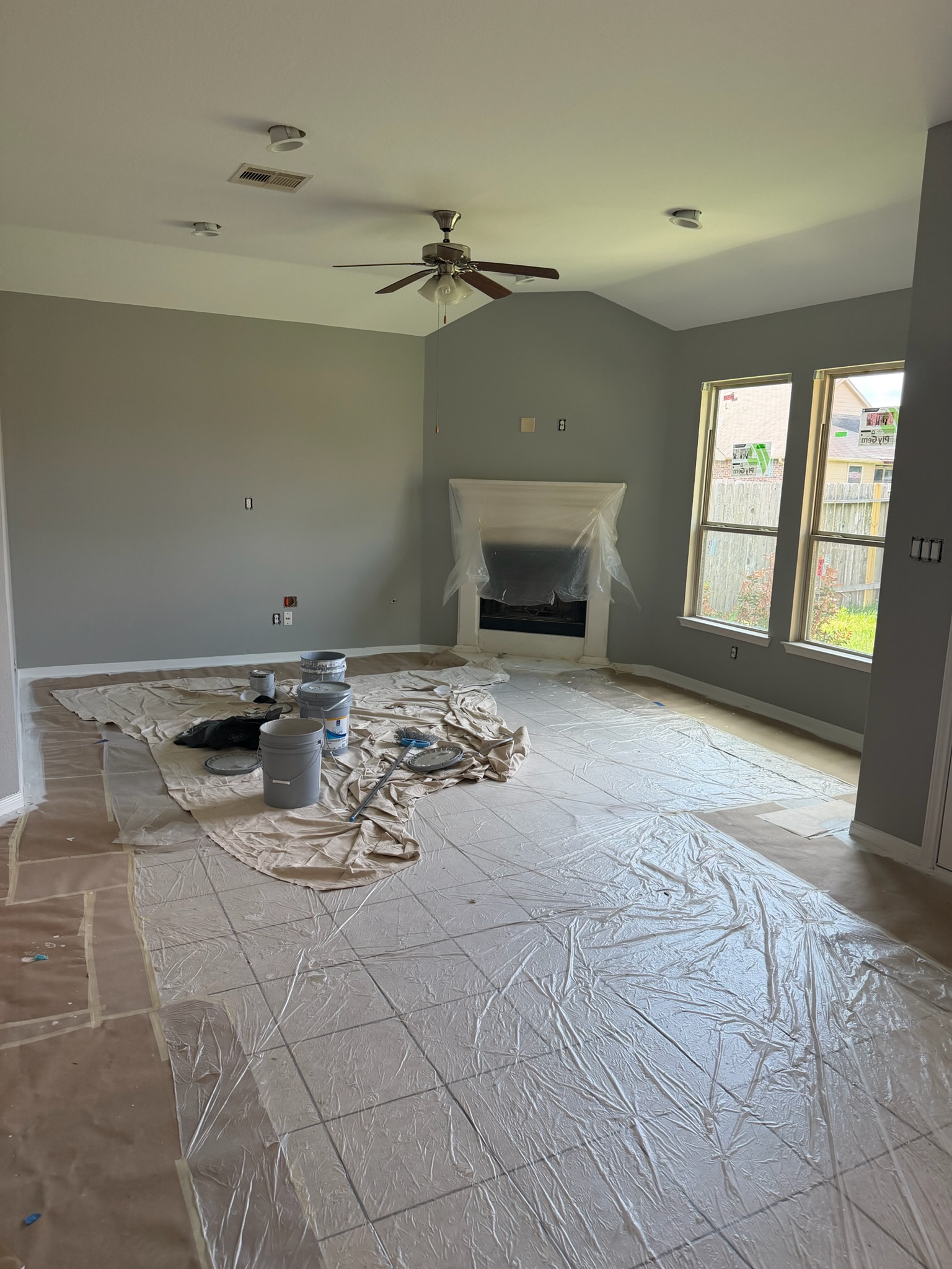 Professional interior painting of a white fireplace mantle against a soft sage green wall in a clean living room.