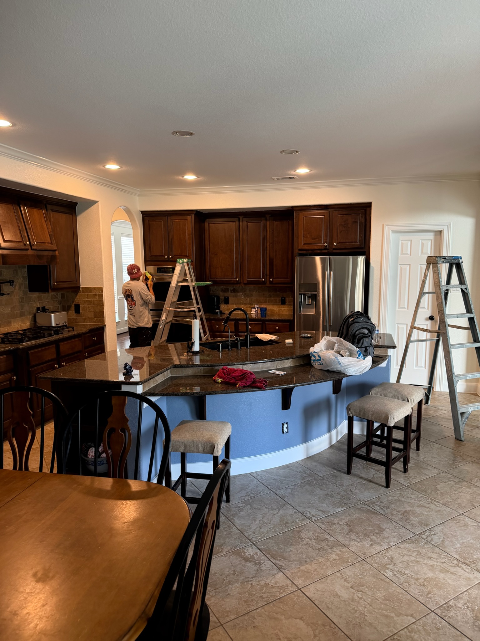 Professional painter applying Sherwin-Williams coating to luxury home trim with precision.
