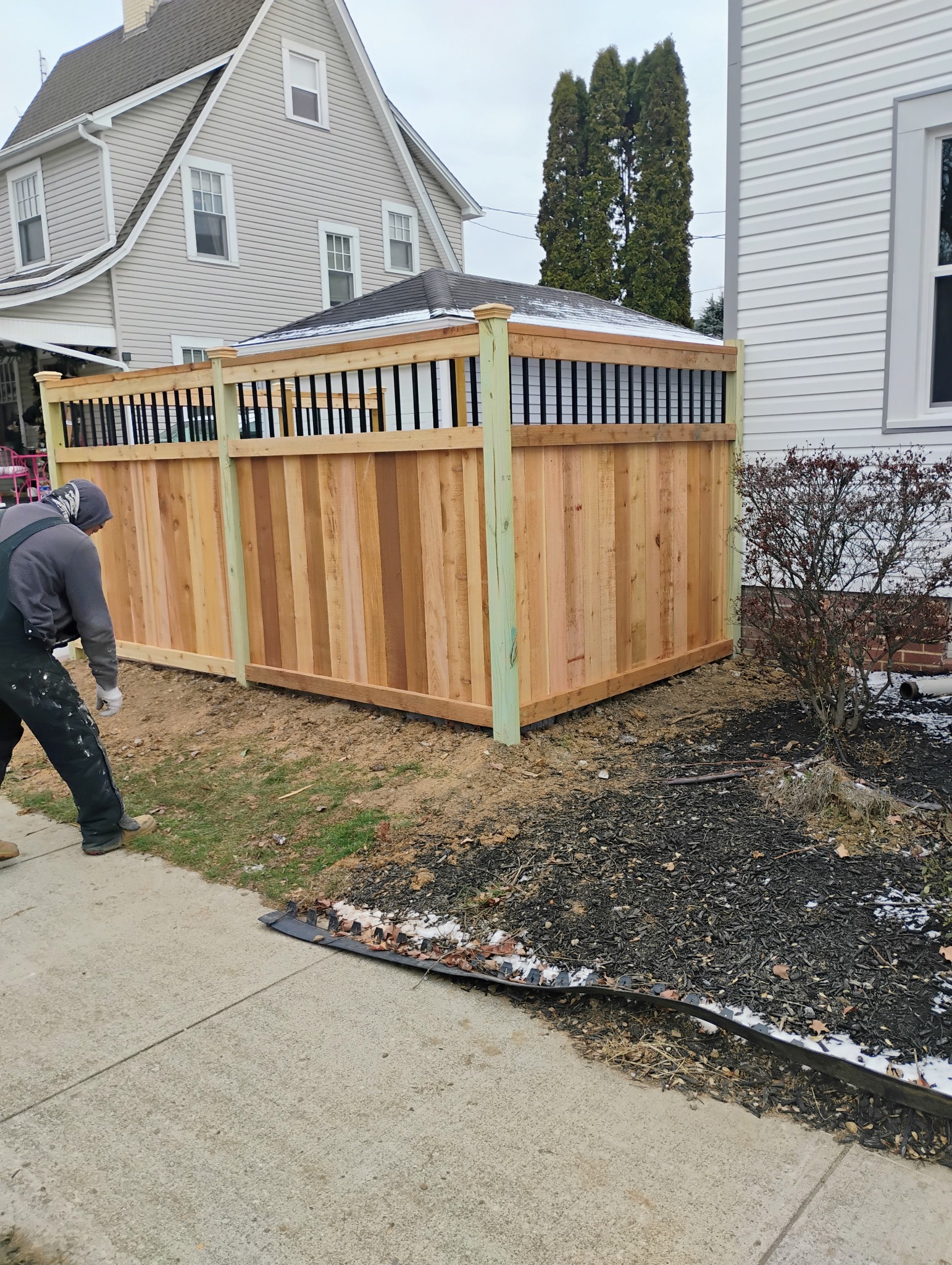 Custom wood privacy fence with black metal baluster top rail in Worthington, OH.