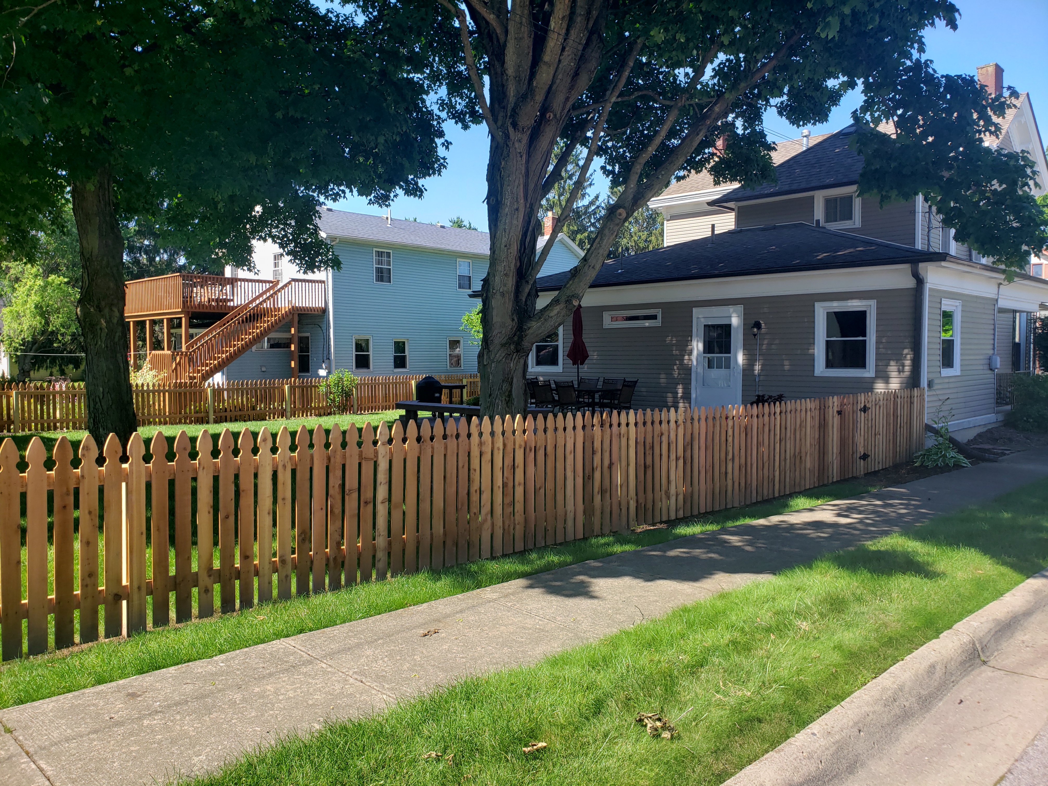 Classic vertical spaced wood picket fence along a front yard sidewalk in Bexley, OH.