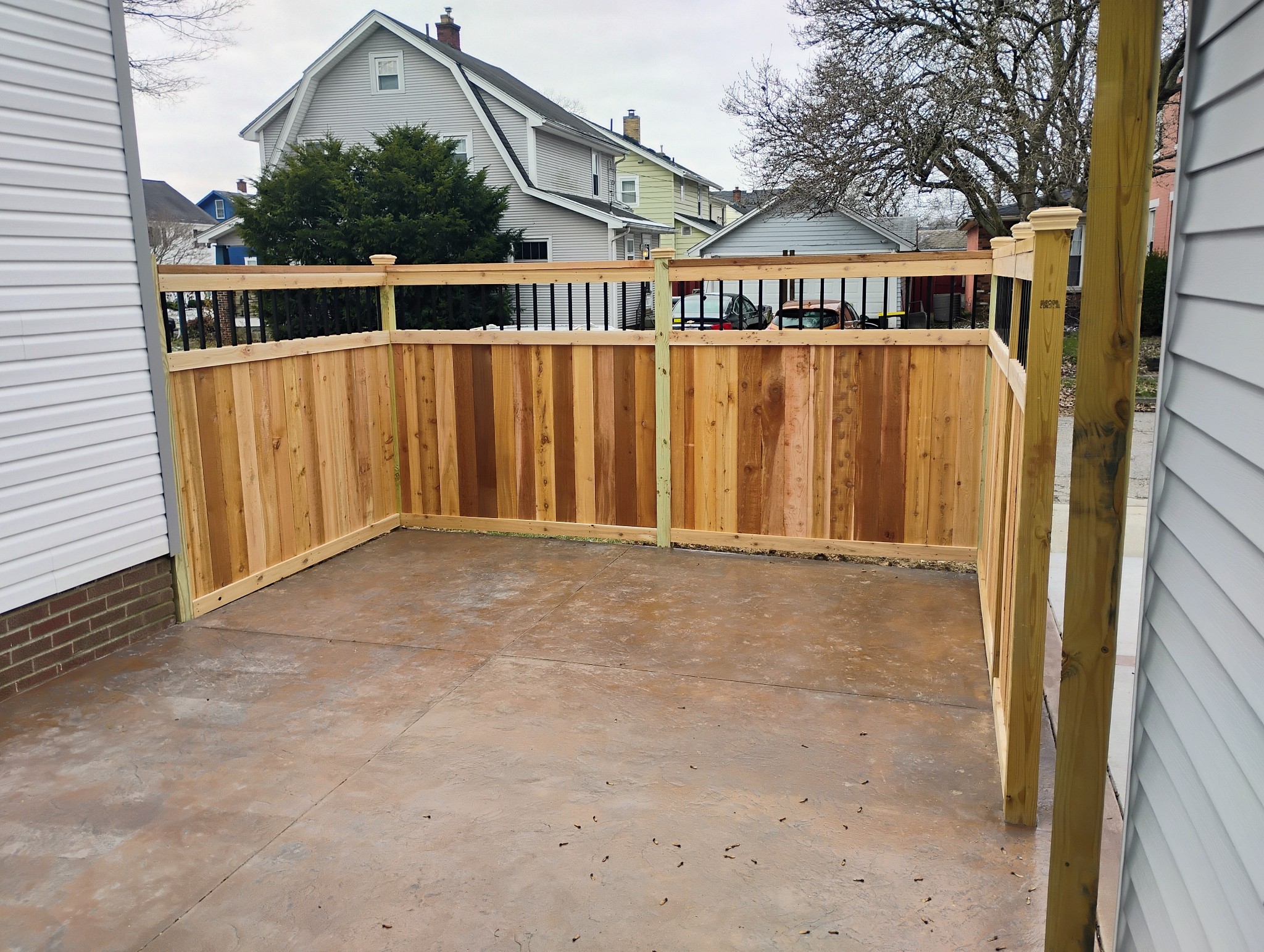 Solid wood privacy fence wrapping a concrete backyard patio in Columbus, OH.