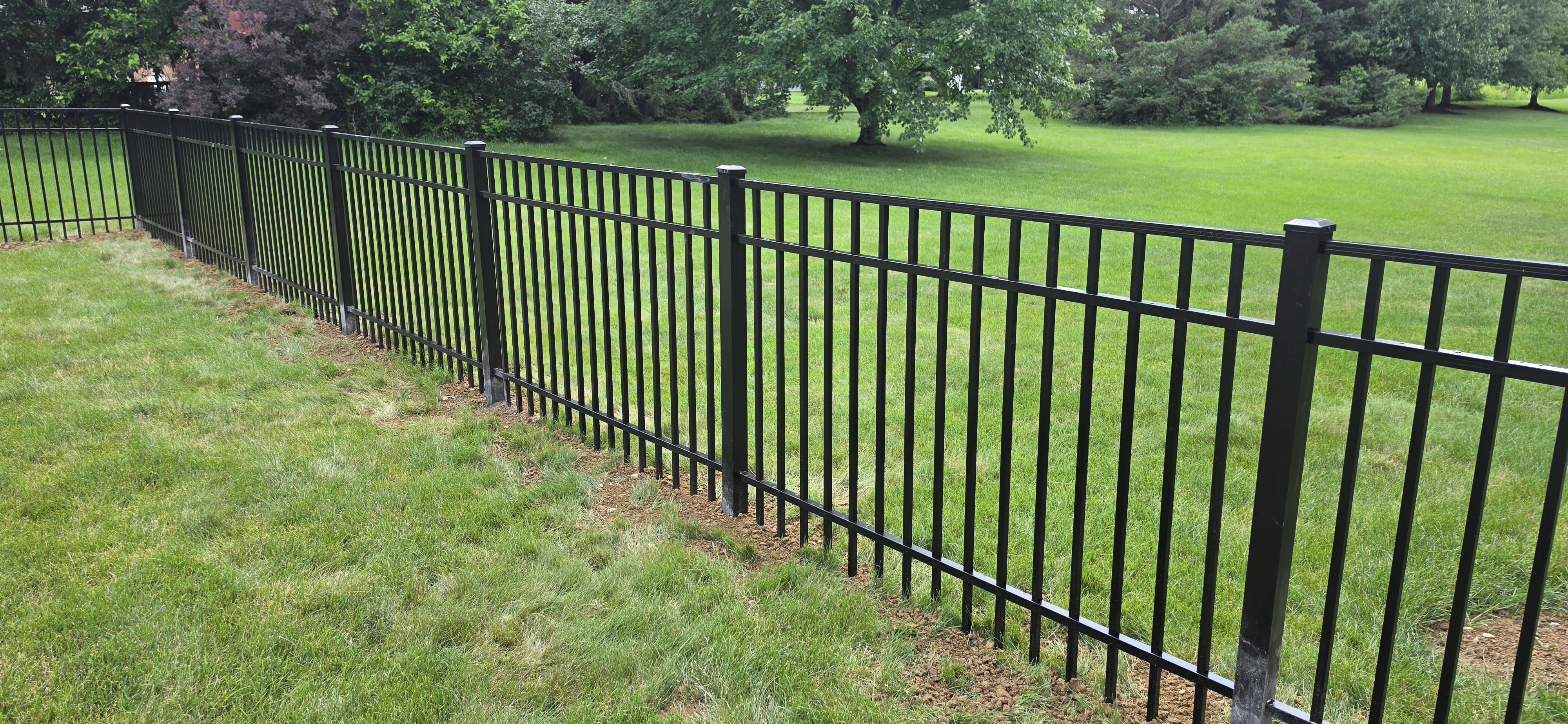 Classic flat-top black aluminum fence enclosing a backyard in Lancaster, OH.
