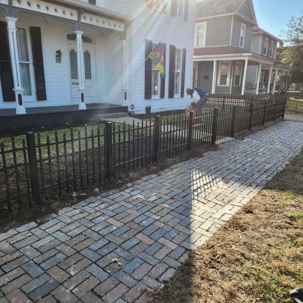 Modern flush-bottom aluminum fence over a concrete patio in Delaware, OH.