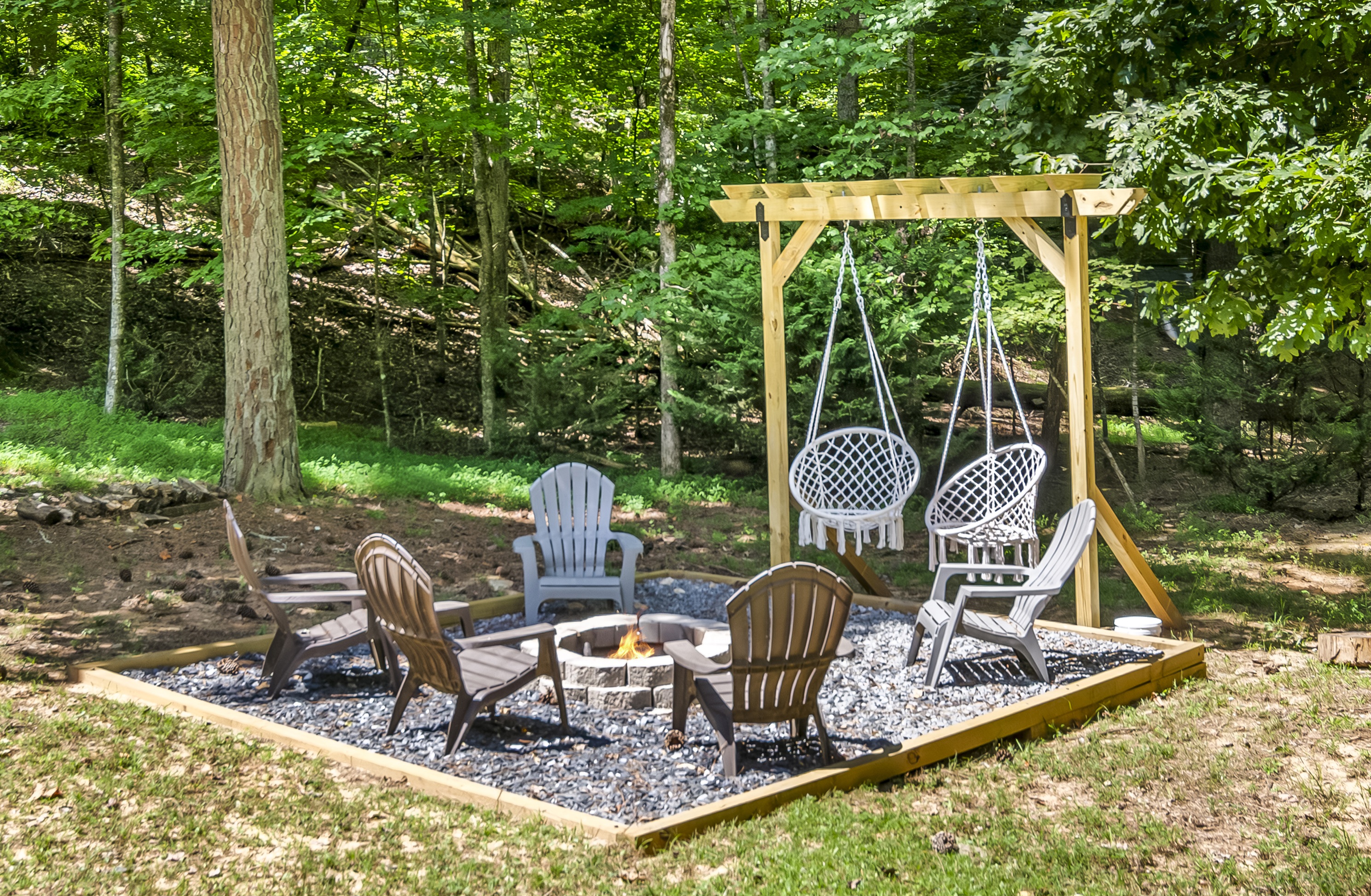 Stone fire pit with Adirondack chairs at the cabin