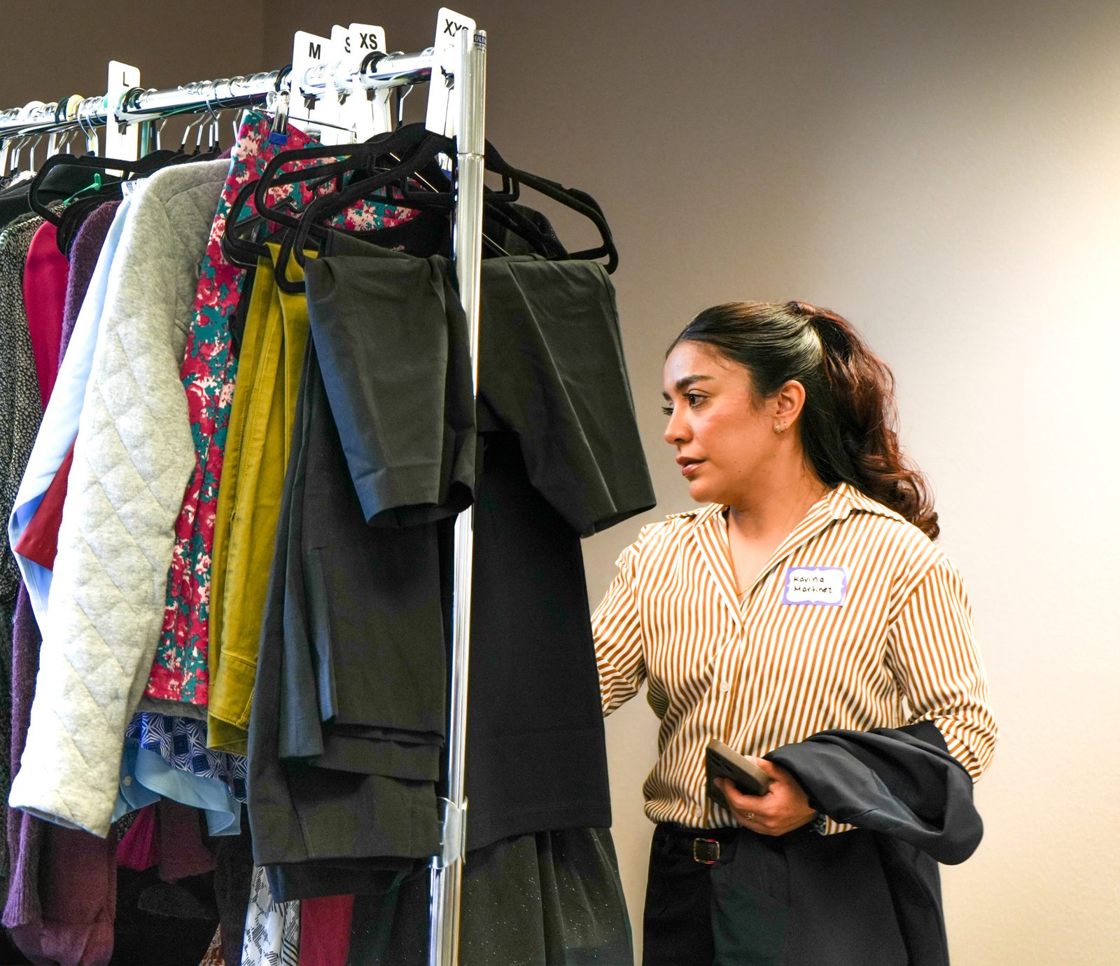 A volunteer choosing clothes from a full rack at Best Foot Forward in Napa