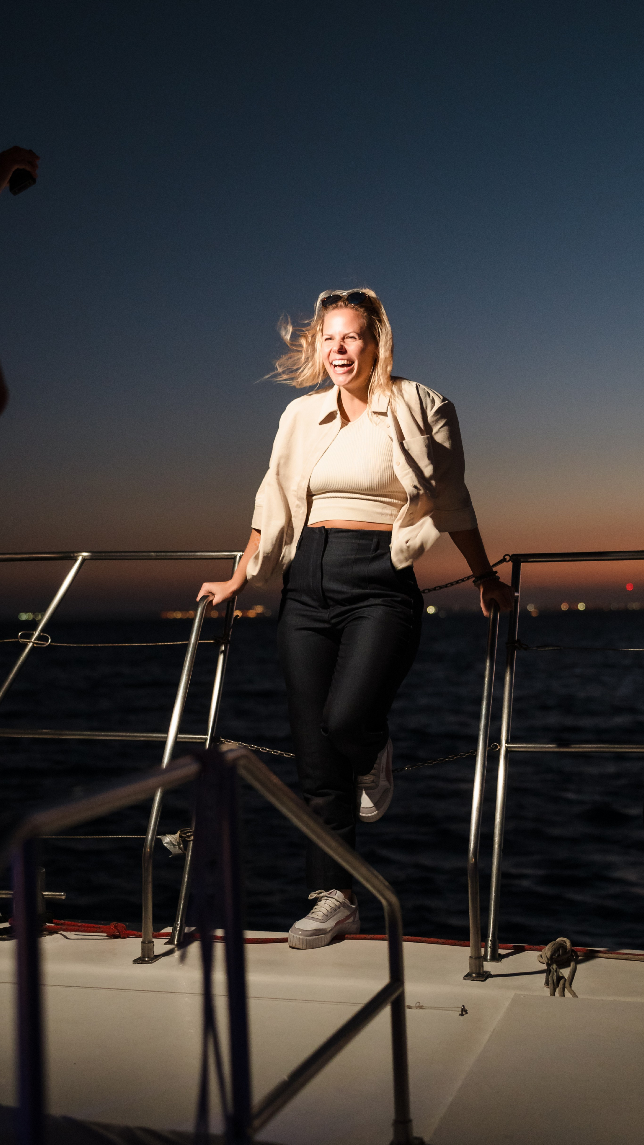 Dr. Alina Behne lacht im Sonnenuntergang auf einer Yacht