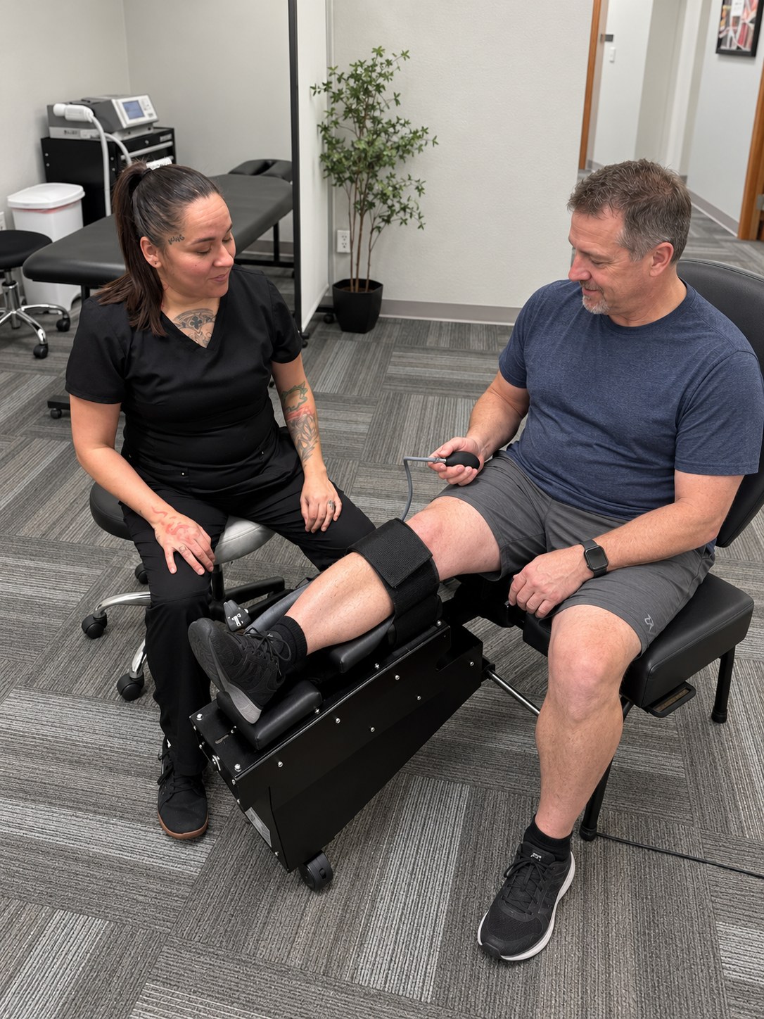 A patient on the Knee on Trac decompression device with an Althoff Wellness Clinic team member in Cheyenne, WY