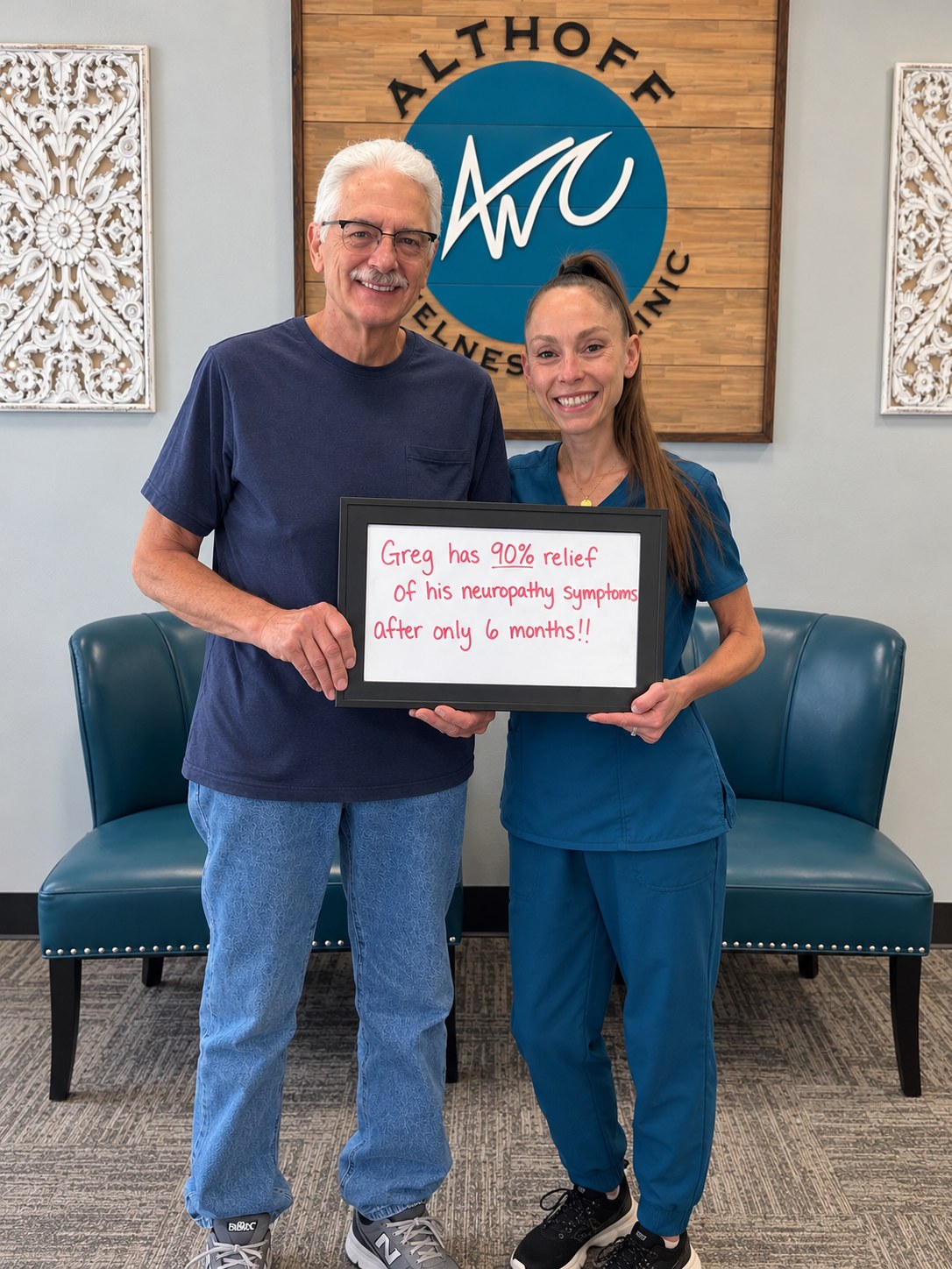 Patient Greg holding a whiteboard about his neuropathy progress with Dr. Jennifer Saboy, DC (Dr. J)