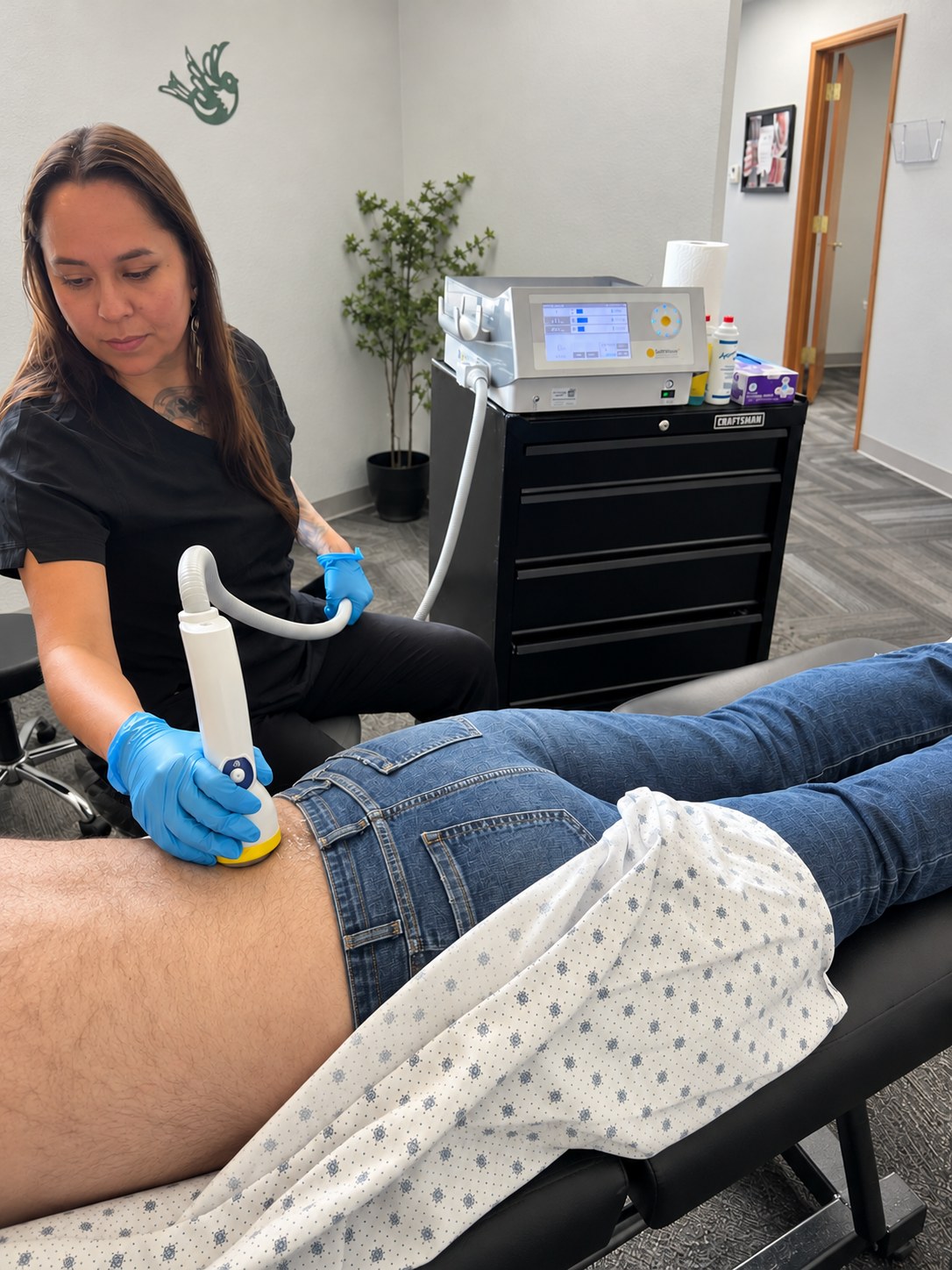 A patient receiving SoftWave shockwave therapy on his lower back at Althoff Wellness Clinic in Cheyenne, WY