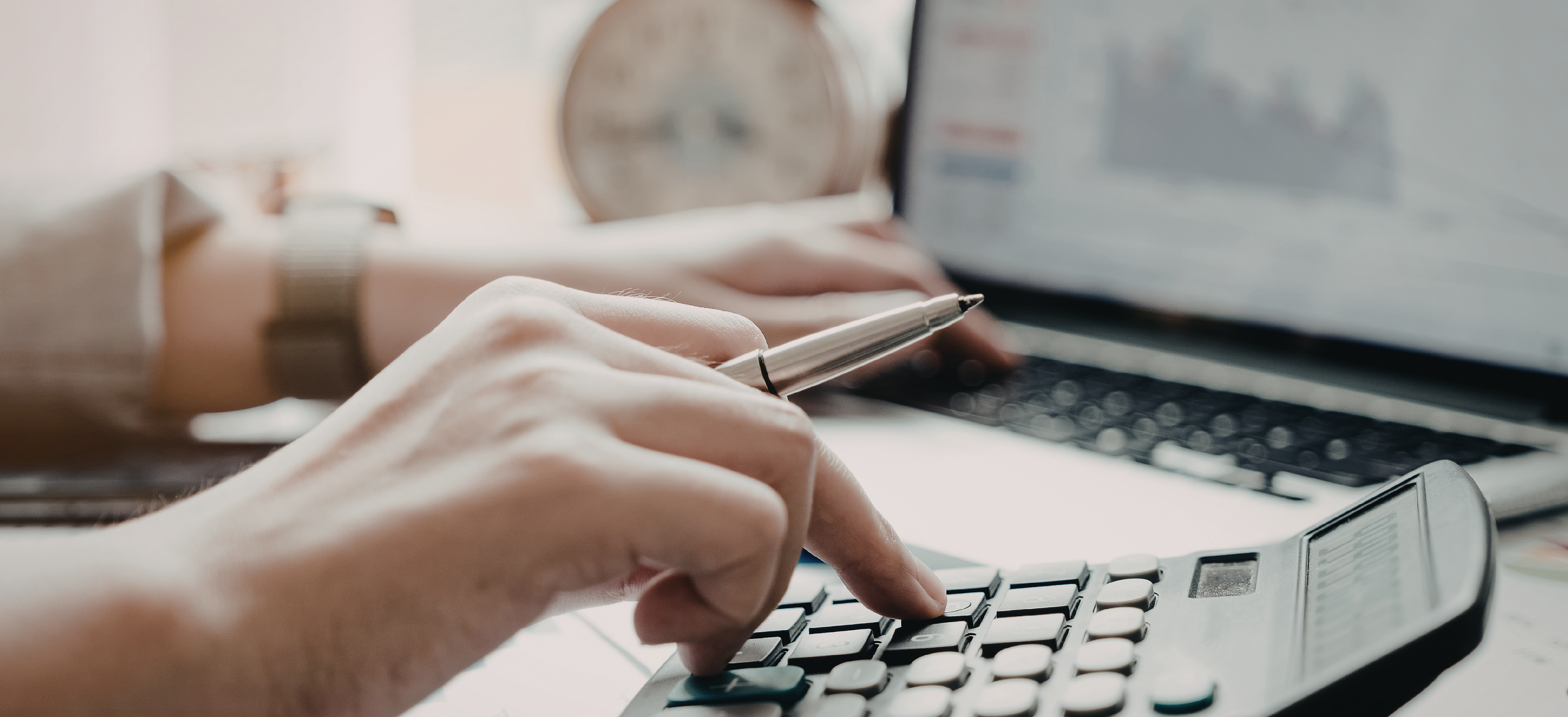 Attorney using a calculator and laptop to review financial data for law firm tax planning