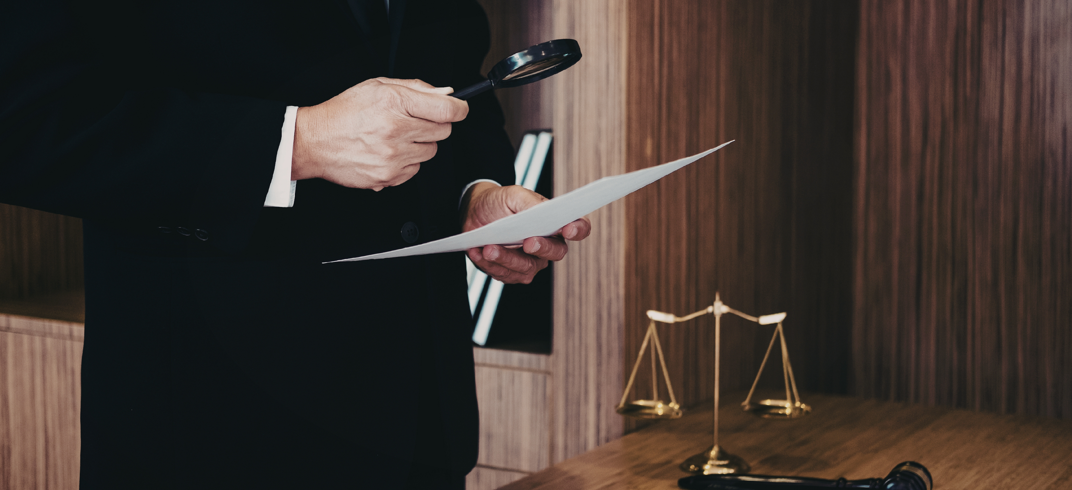 Lawyer examining legal paperwork with a magnifying glass in a law office