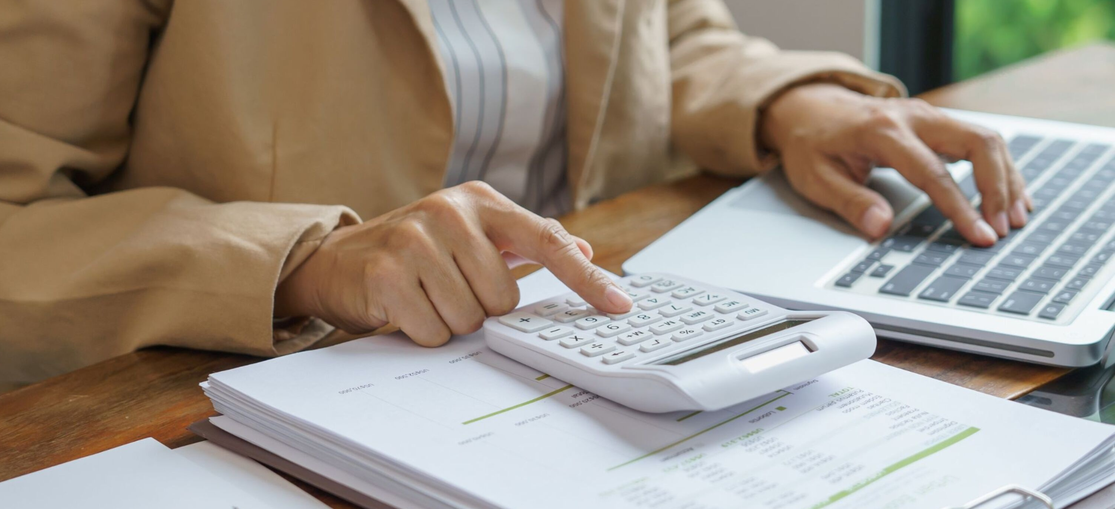Lawyer analyzing financial documents and calculations at a desk, representing tax compliance.
