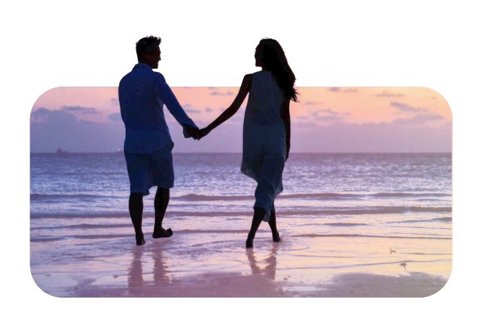 Una pareja, tomados de las manos, caminan por la playa respirando y latiendo al unísono.