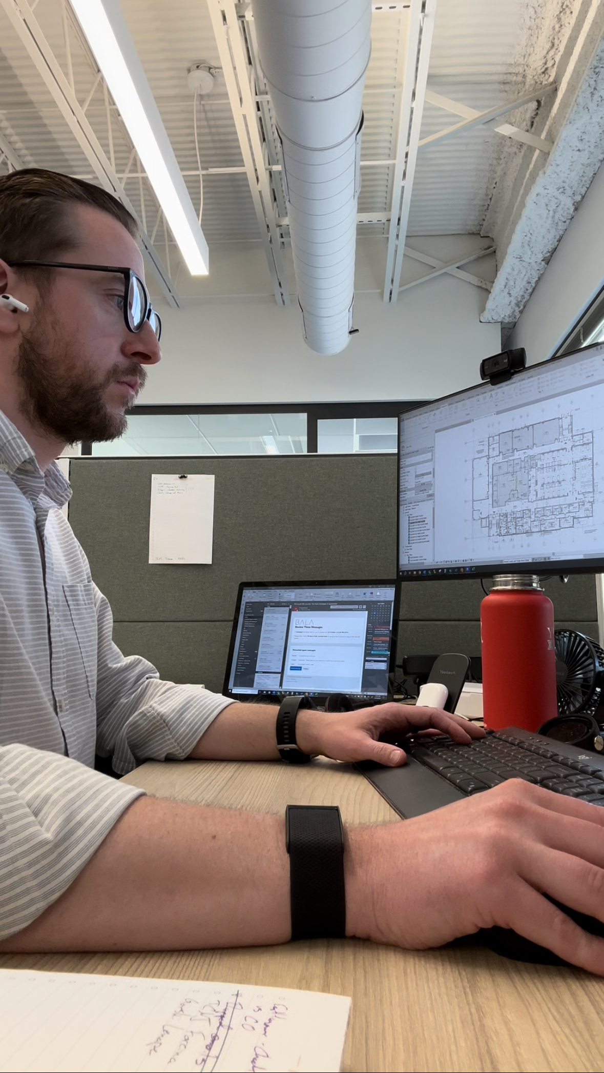 Spencer Gallo working at a desk reviewing construction plans on dual monitors