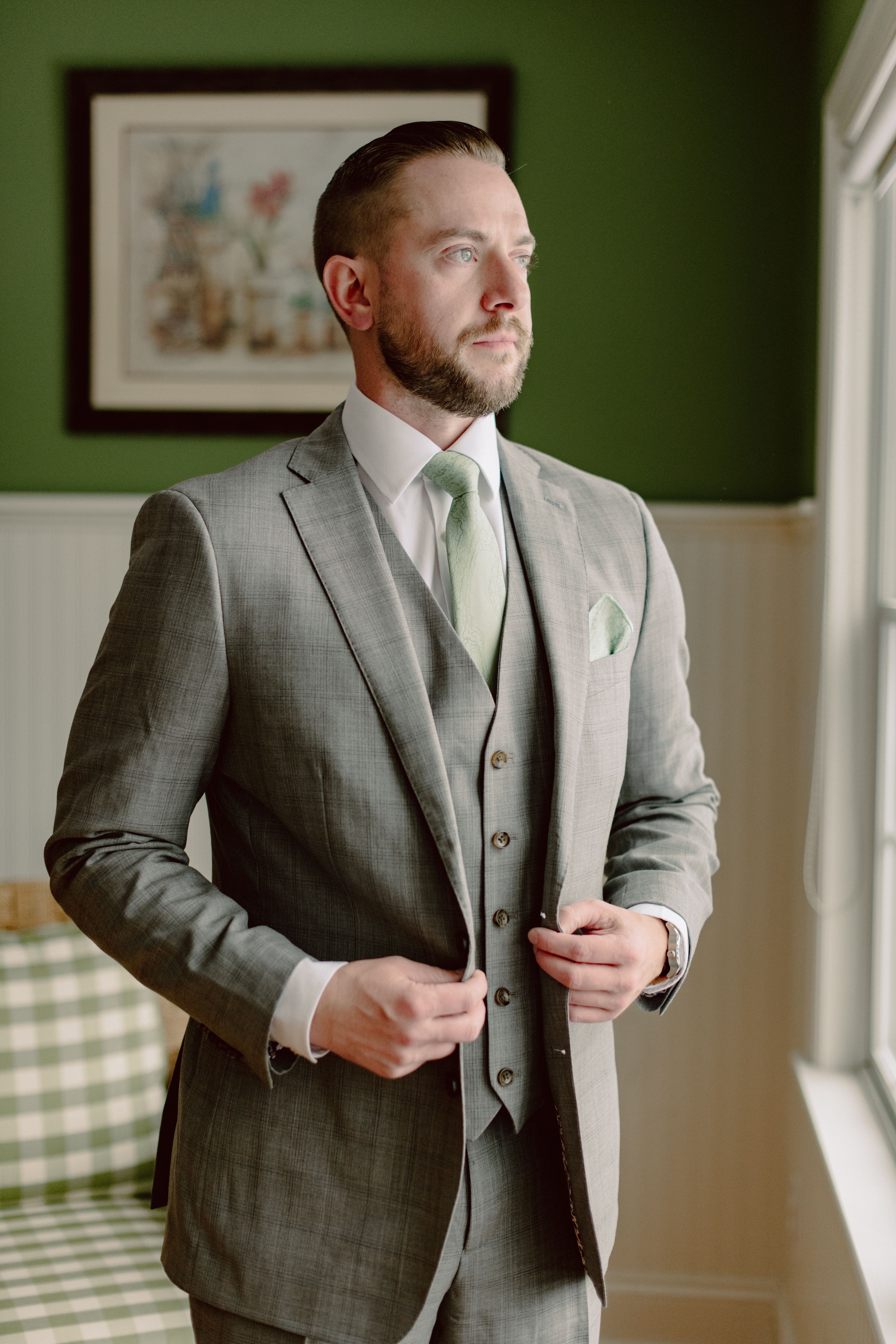 Spencer Gallo dressed in a suit, looking out a window, representing leadership and professionalism