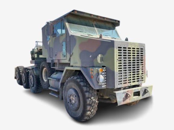 A camouflage-patterned military truck with multiple axles and heavy-duty tires.